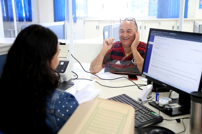 O segurado do INSS, Edinei Gomes Pereira, recebendo atendimento no guichê da APS em Planaltina / DF.