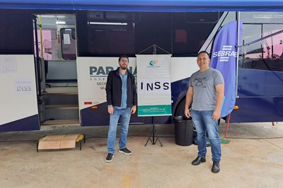 O gerente da APS de Laranjeiras do Sul, Welington Luiz da Rosa, e o servidor do INSS, Marcelo Beck de Sá, posam em frente a unidade móvel em que o INSS está atendendo à população.