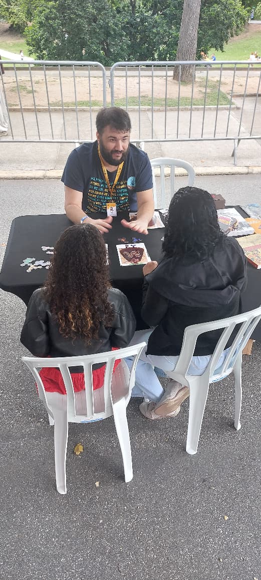 Três pessoas ao redor de uma mesa jogando com cartões