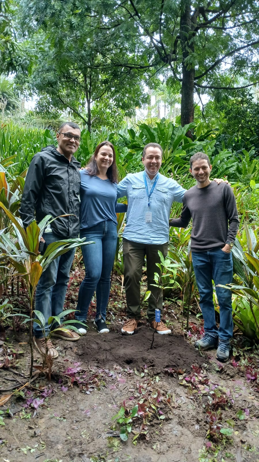 dois homens e uma mulher juntos no meio de plantas
