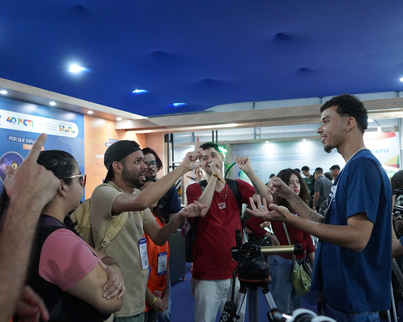 Leandro e Wesley durante conversa, em Libras, com educador museal bilíngue do MAST