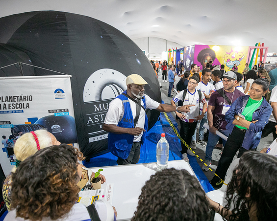 Educador museal conversa com participantes à espera da sessão de planetário do MAST