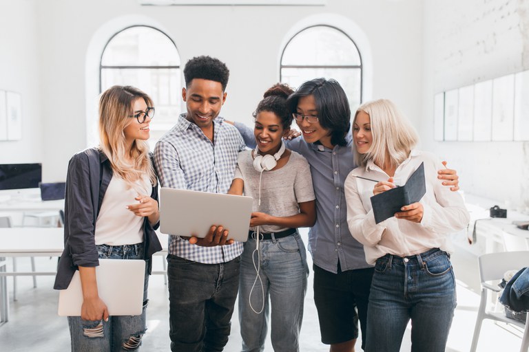 handsome-african-guy-black-jeans-holding-laptop-showing-co-workers-presentation-indoor-portrait-asian-man-glasses-embracing-blonde-woman-posing-with-other-employees.jpg