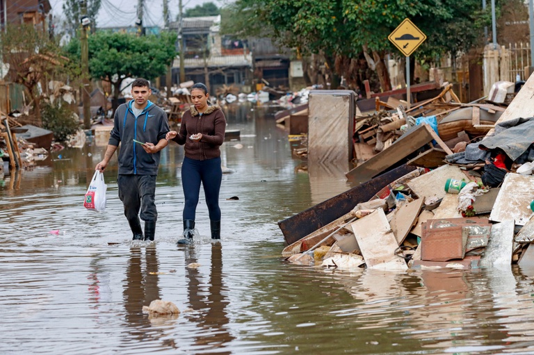 Moradores em rua alagada pela enchente no município de Eldorado do Sul (RS) em junho de 2024. Foto: Bruno Peres/Agência Brasil