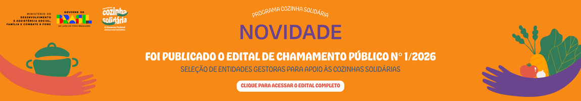 "Banner do Programa Cozinha Solidária com fundo laranja. À esquerda, o texto ‘Programa Cozinha Solidária – O Governo Federal abraça esta iniciativa’, ilustrado com braços roxos em formato de abraço. À direita, ilustrações de legumes e verduras, como tomate, cenoura, cebola e folhas verdes, também envoltos por braços roxos."