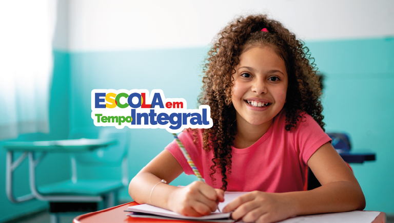 Estudante escreve em caderno em sala de aula ao lado do logotipo do programa Escola em Tempo Integral, iniciativa do MEC para ampliar a jornada e a aprendizagem na educação básica.