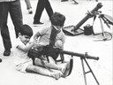 Crianças brincam com metralhadora em exposição bélica no Rio de Janeiro em agosto de 1964