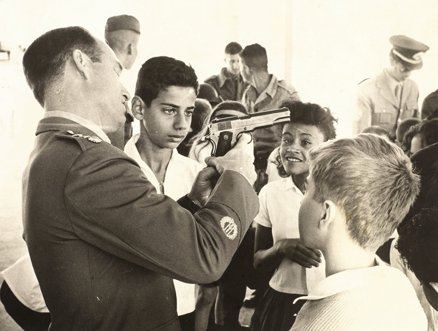 Militar mostra arma para crianças em exposição bélica em Brasília em agosto de 1964