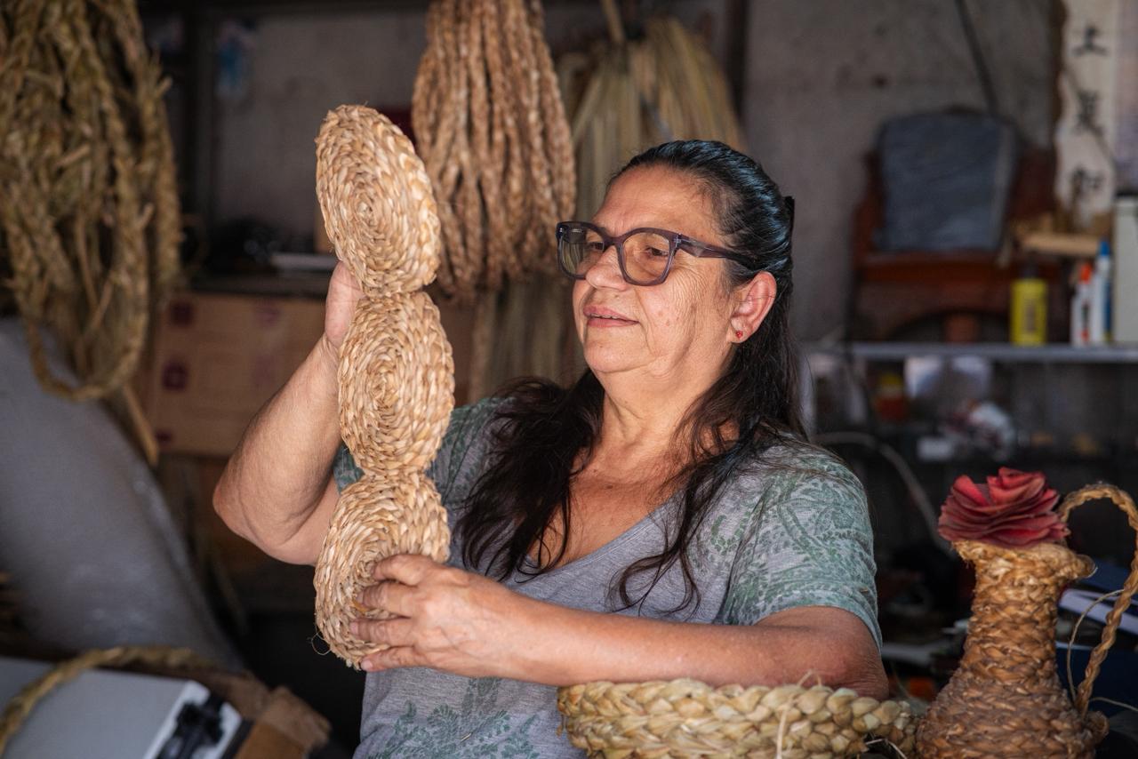Mulher com artesanato de palha na mão