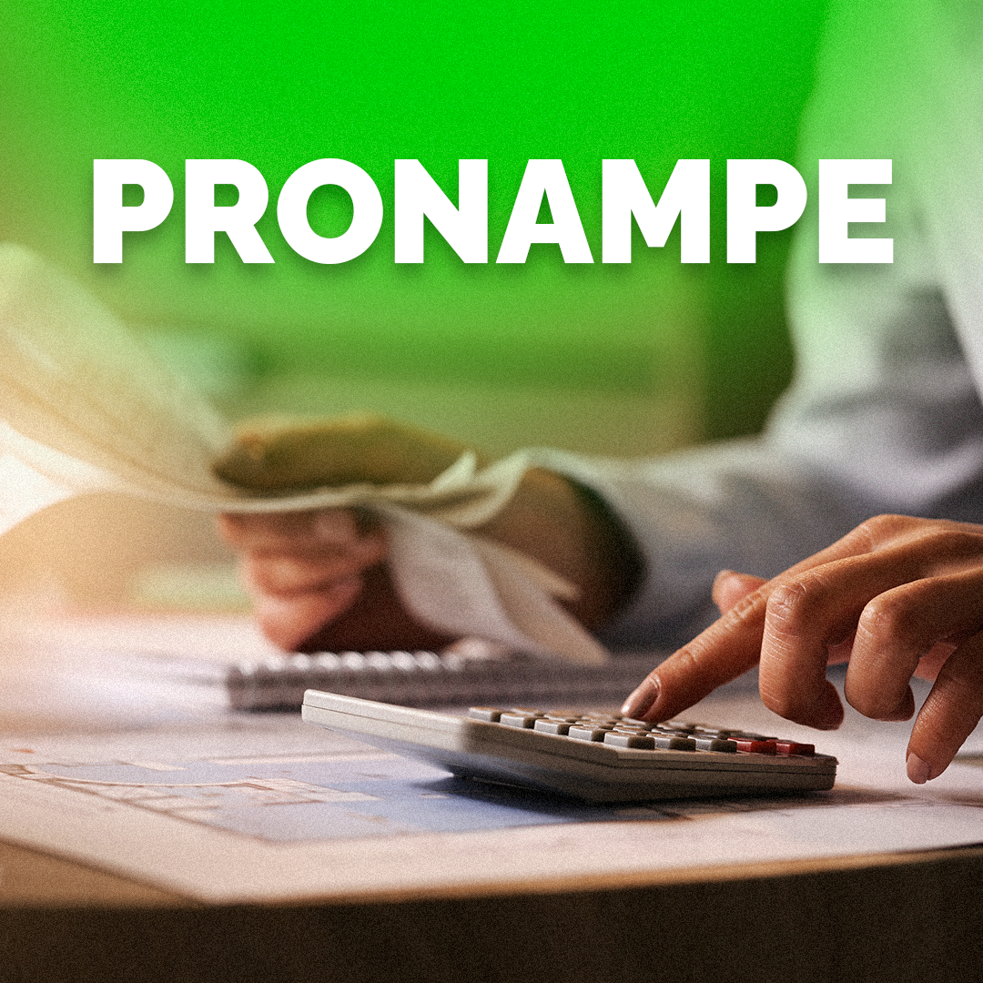 Pessoa com um papel na mão e utilizando a calculadora escrito em cima Pronampe