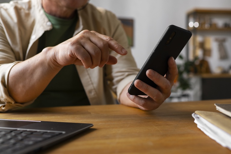 portrait-older-man-using-smartphone-home.jpg