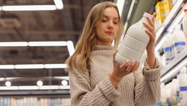 grocery-shopping-female-read-milk-bottle-in-shop-2022-04-07-20-09-10-utc.jpg