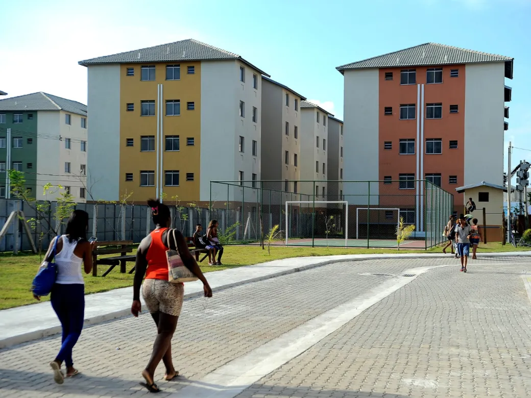 Duas mulheres caminham em direção a um conjunto habitacional do Minha Casa Minha Vida