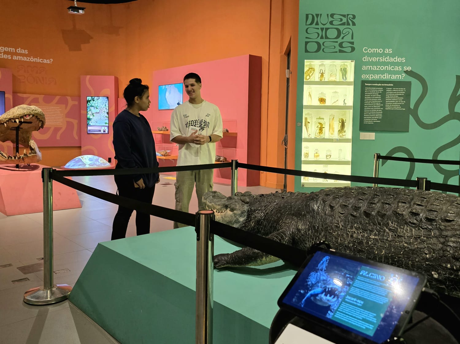 Casal de jovens conversam em ambiente de exposição