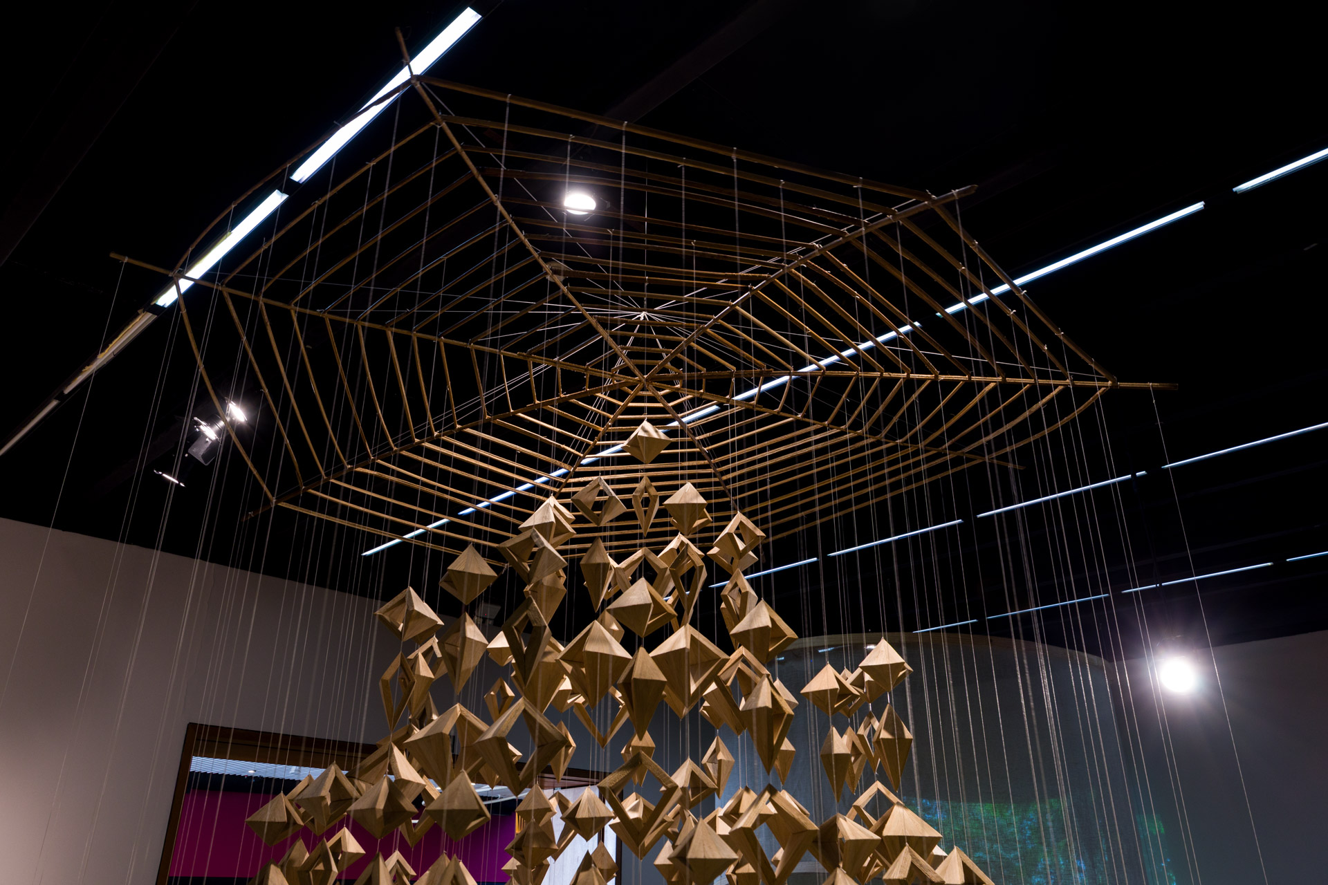 instalação artística imitando teia de aranha com objetos penduradas nela