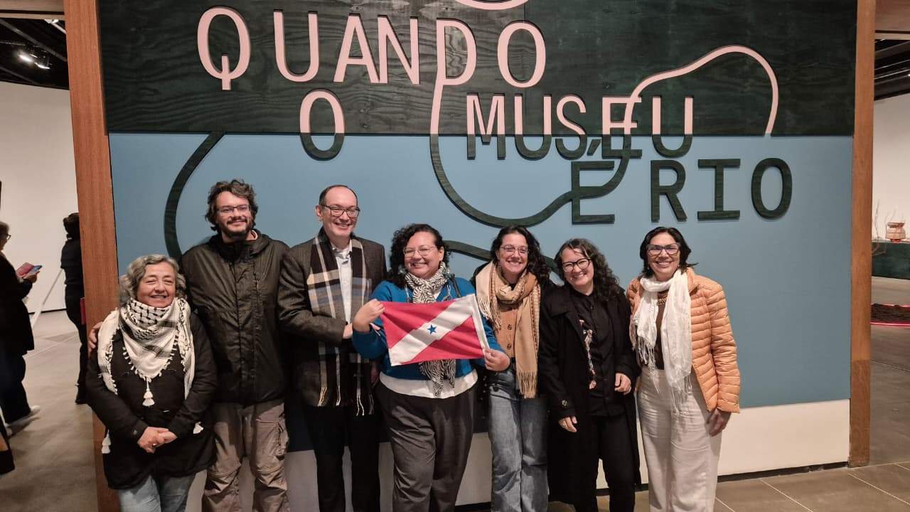 grupo de sete pessoas - cinco mulheres e dois homens - posam sorrindo para fotografia