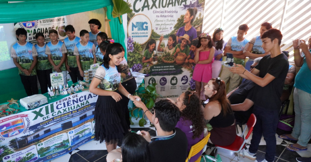 Em um ambiente de feira de ciências, estudante oferece produto a avaliadores