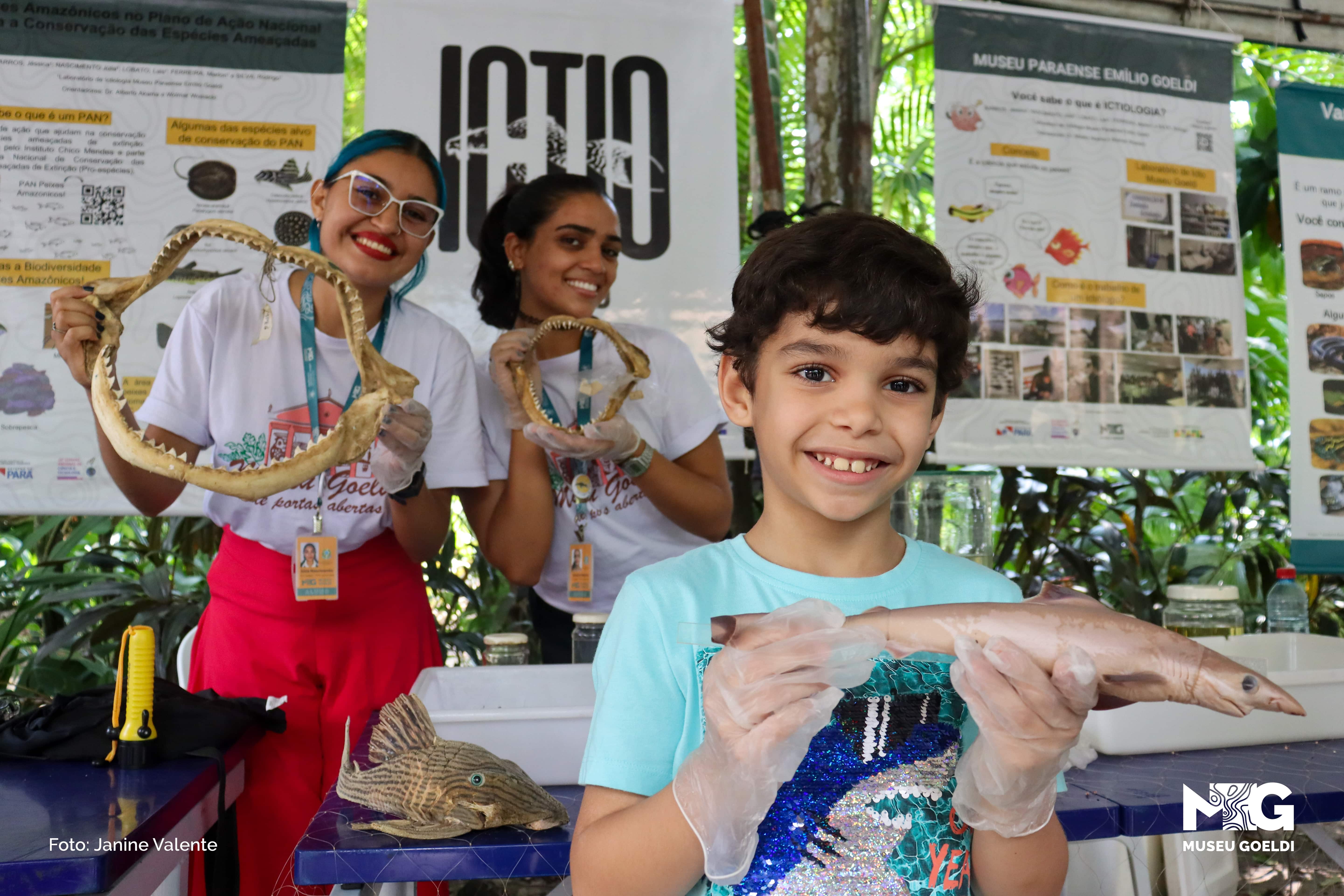 Um menino segura um peixe numa exposição científica