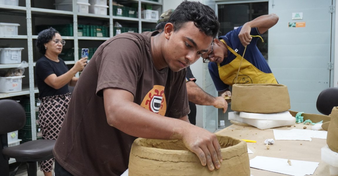 Participante Gidean Moraes trabalhando na réplica em cerâmica da urna funerária Aristé