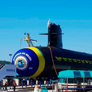 Imagem da galeria de imagem da página de Defesa. A imagem mostra um submarino sendo inaugurado em um porto. O cenário principal é o céu azul.