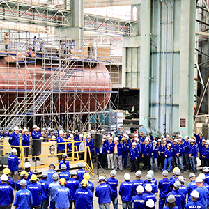Imagem da galeria de imagem da página de Expertise e Serviços. A imagem mostra uma grande reunião sendo realizada com dezenas de funcionários no galpão de uma fábrica.