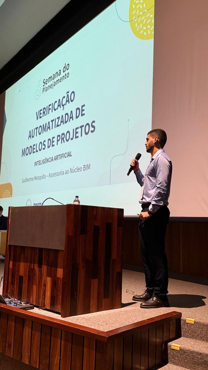 Técnico do DNIT apresentando com slide ao fundo escrito "Verificação automatizada de modelo"