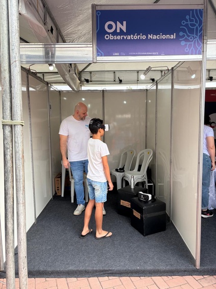 MSc. Rodrigo Cassaro, gestor substituto da Divisão de Comunicação e Popularização da Ciência do ON, auxilia participante na atividade de Realidade Virtual no Festival da Ciência. Foto: ON. 