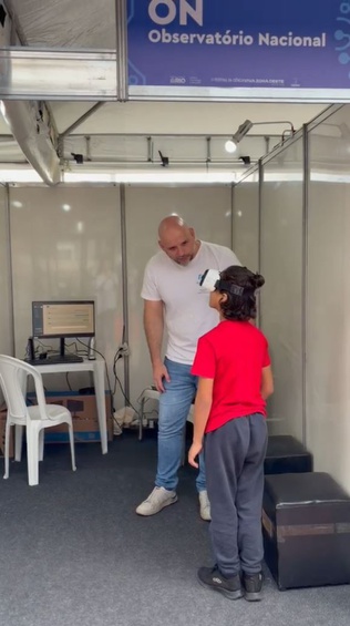 MSc. Rodrigo Cassaro, gestor substituto da Divisão de Comunicação e Popularização da Ciência do ON, auxilia participante na atividade de Realidade Virtual no Festival da Ciência. Foto: ON.