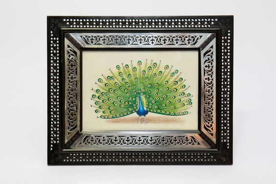 Porta-retrato em madeira escura, trabalhado com a técnica 'jali' representando um pavão com a calda aberta