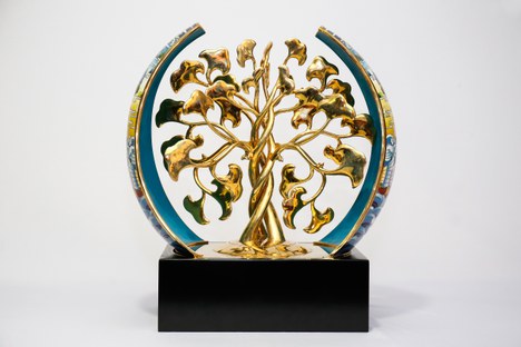 Escultura em metal dourado, representando duas árvores de troncos interligados