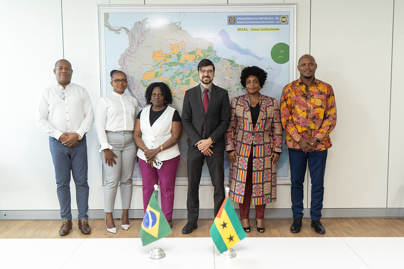 Pessoas posam pra foto em frente ao mapa do Brasil
