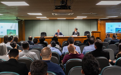 Dois homens em mesa de auditório