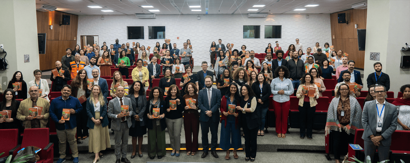 Pessoas em auditório seguram publicação