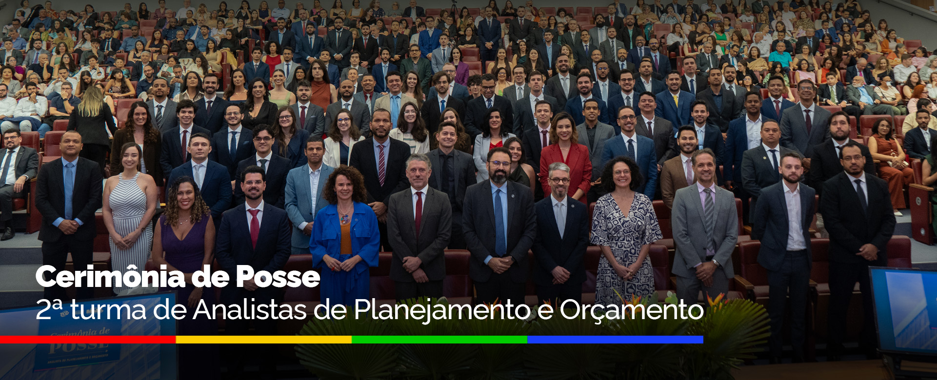 Pessoas posam para foto em auditório