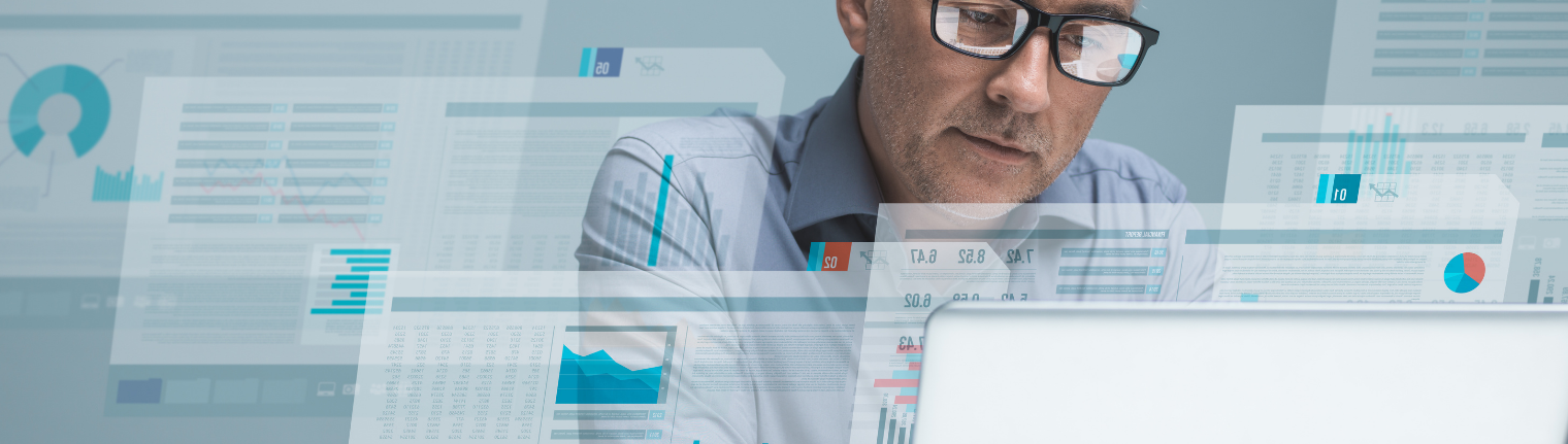 Homem olhando números e gráficos na tela do computador