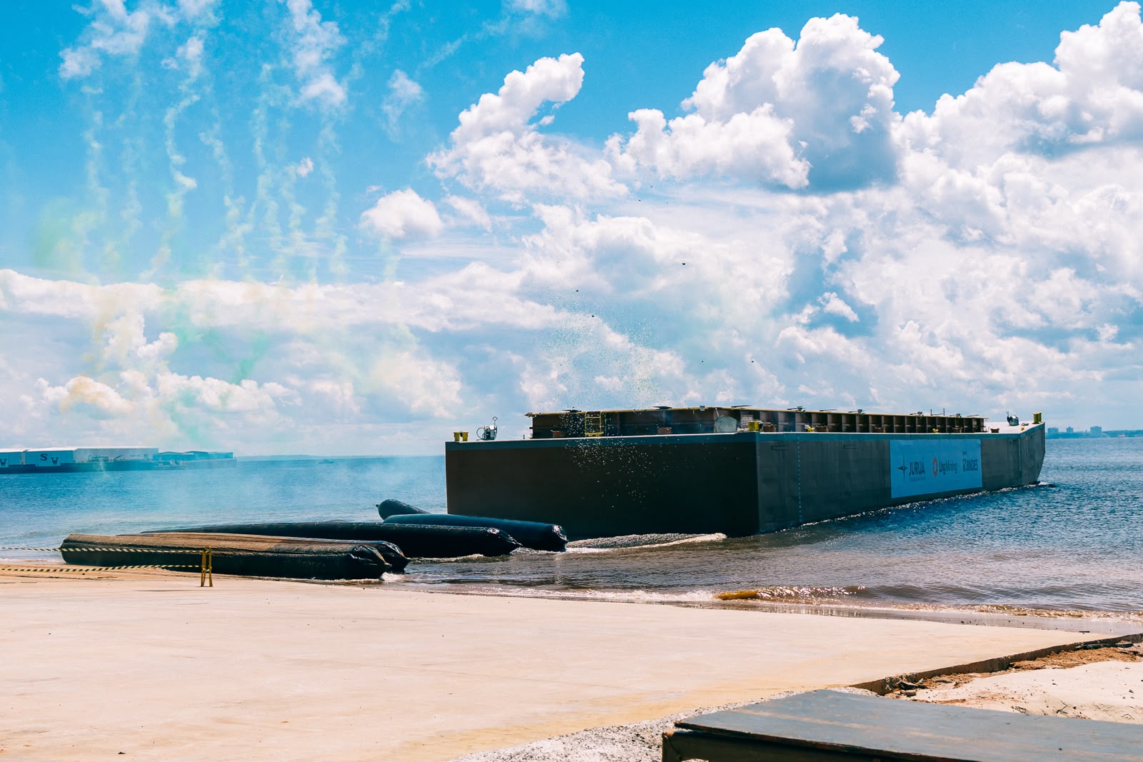 Balsa flutuante às margens do rio, em Iranduba, no Amazonas, sob céu azul com grandes nuvens brancas durante operação naval.