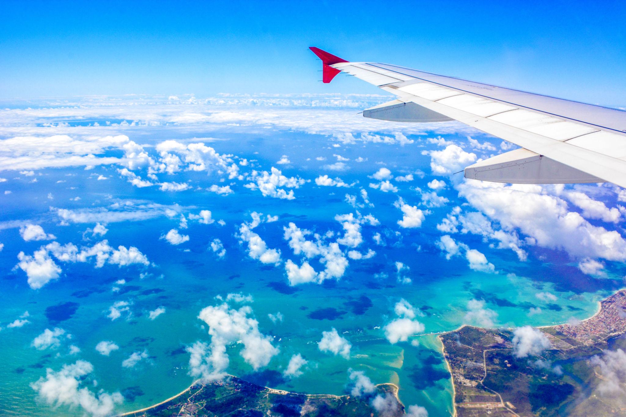 Vista aérea a partir da janela de um avião, com a asa da aeronave em primeiro plano e paisagem de Campo Grande, em Mato Grosso do Sul, abaixo.
