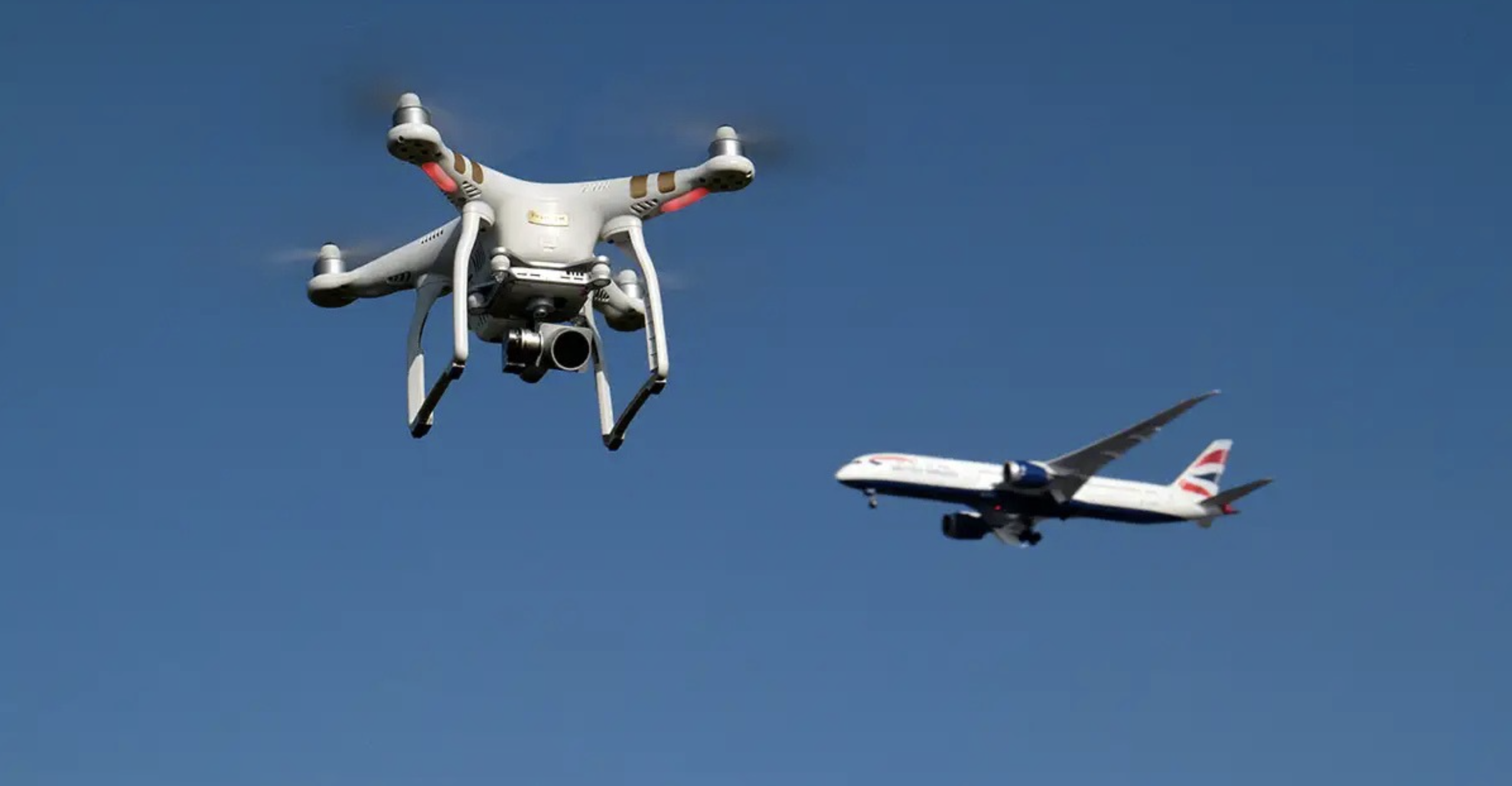 Drone em voo próximo a uma aeronave comercial durante procedimento de aproximação.