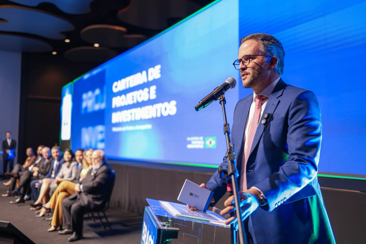 Ministro Tomé Franca discursa num palco, ao lado de autoridades.