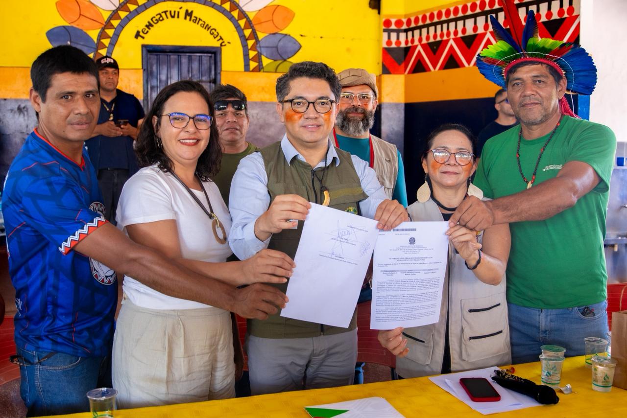 Ministro dos Povos Indígenas e presidenta da FUNAI seguram documento assinado ao lado de lideranças e representantes indígenas