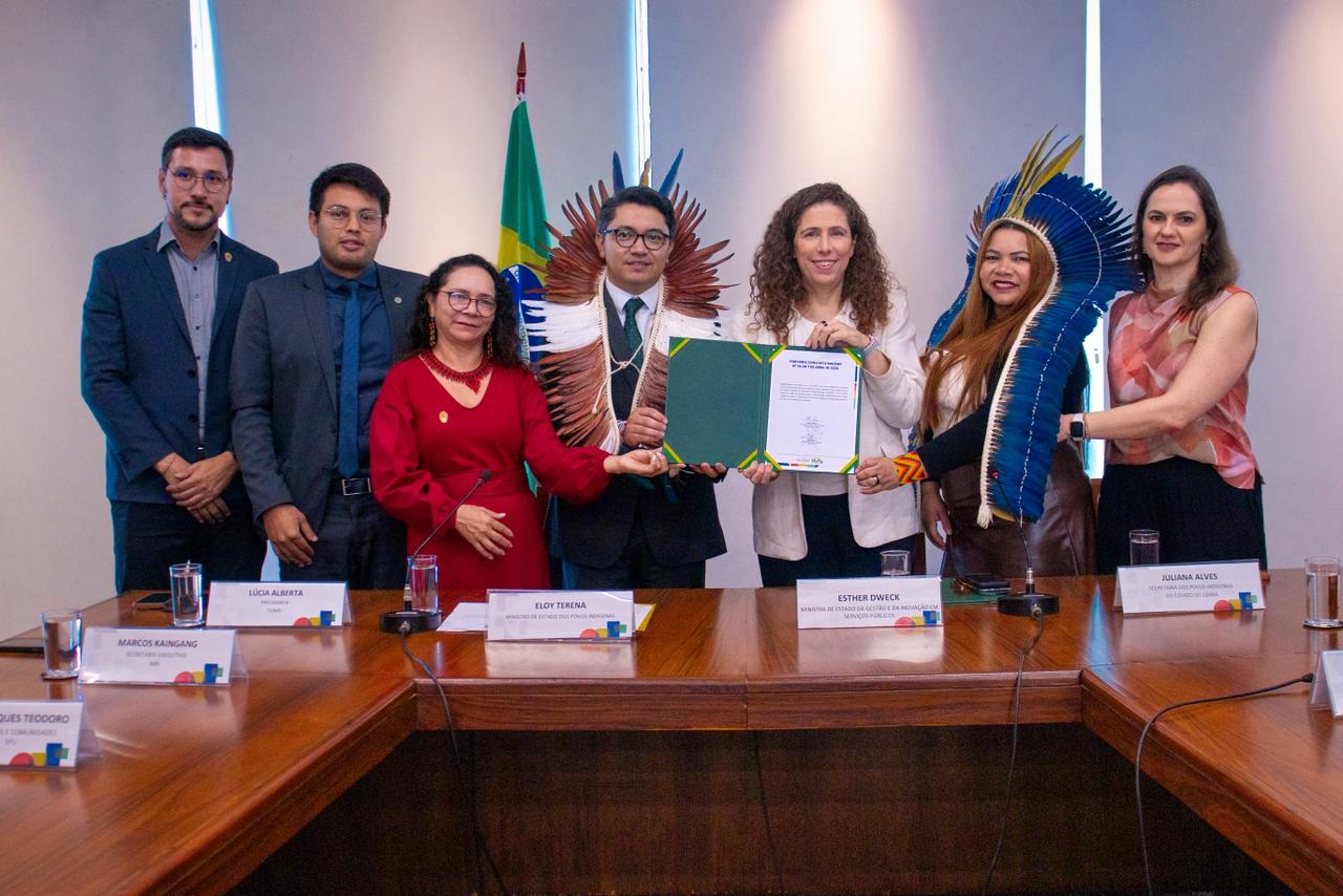 Representantes do governo federal e seguram documento da Portaria 14