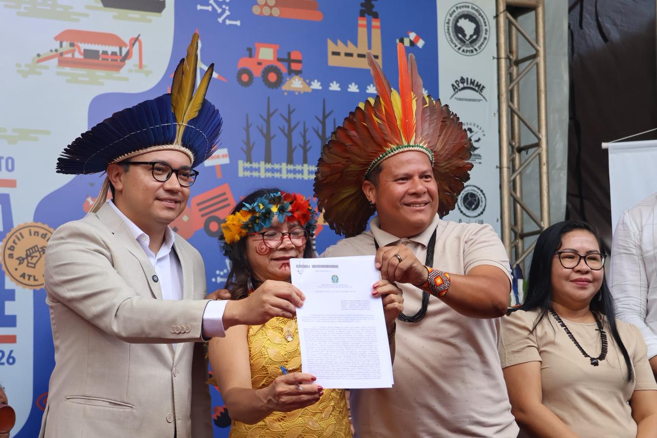 Lucia Baré segura documento entre o ministro dos Povos Indígenas e o coordenador executivo da APIB