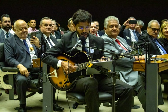 Servidor André Sakai canta durante a sessão