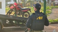 Policial Rodoviário Federal em frente à motocicleta recuperada