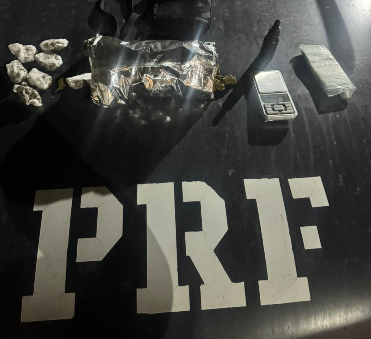 Droga apreendida em cima do capô da viatura