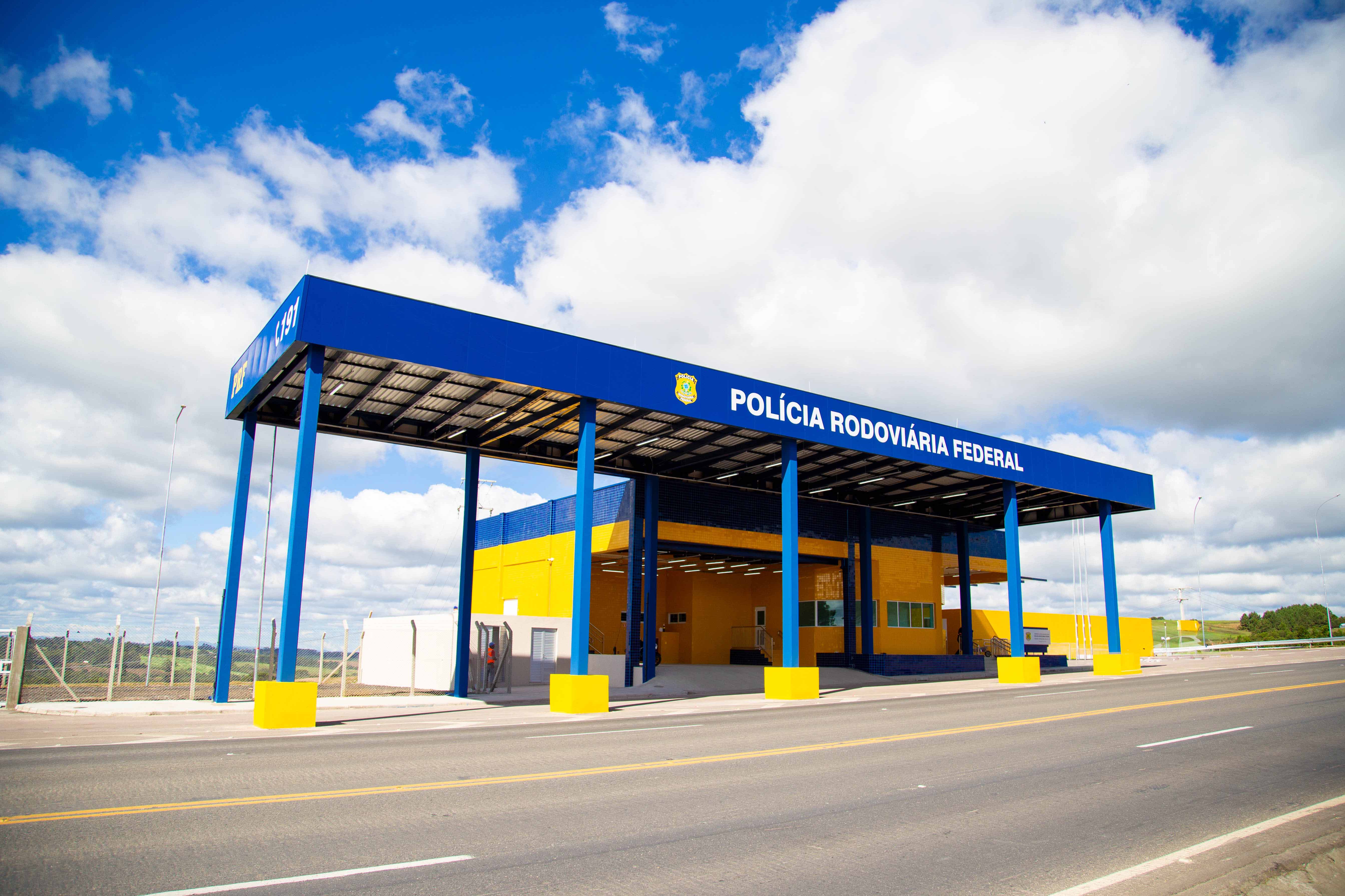 Posto da PRF nas cores azul e amarelo, com céu azul ao fundo