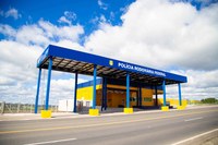 Posto da PRF nas cores azul e amarelo, com céu azul ao fundo