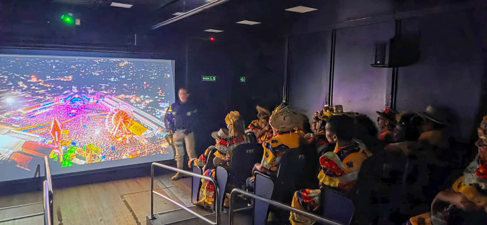 No interior do Cinema Rodoviário da PRF, um policial rodoviário federal realiza uma apresentação par