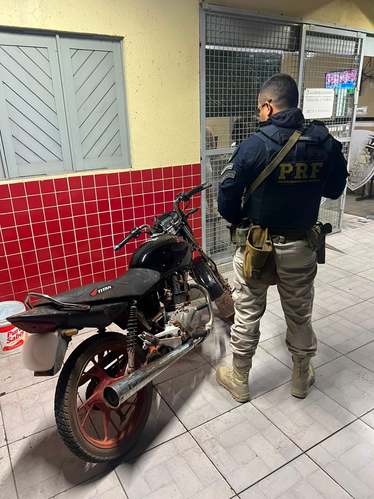 PRF de costas com a moto recuperada ao lado.