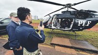 Visitantes conhecem o interior de helicóptero da PRF durante exposição da aeronave em evento aberto ao público.